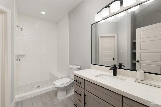 323 Uva Ln, Brownsville, TX 78521 - bathroom featuring a tile shower, toilet, and vanity