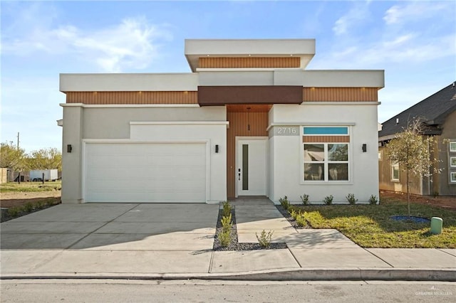 view of front of property with a garage, driveway, and stucco siding