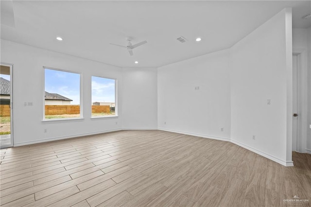 spare room with recessed lighting, a healthy amount of sunlight, and light wood finished floors