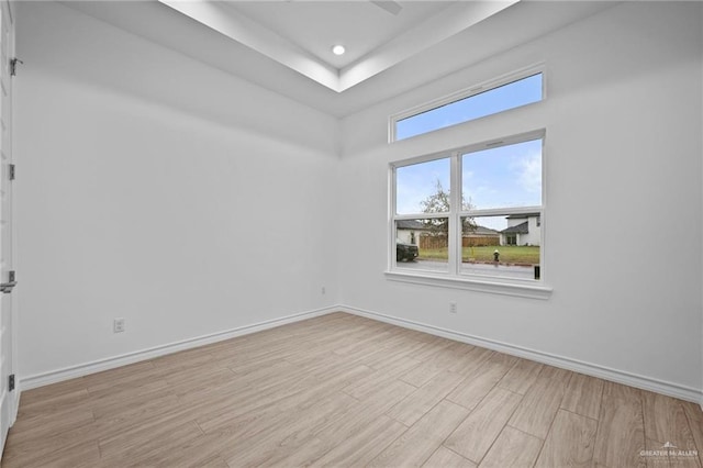 spare room featuring recessed lighting, light wood-style flooring, and baseboards