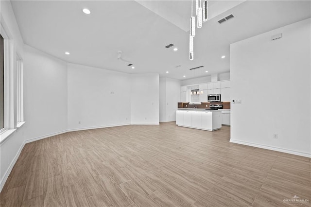 unfurnished living room with recessed lighting, baseboards, visible vents, and light wood finished floors