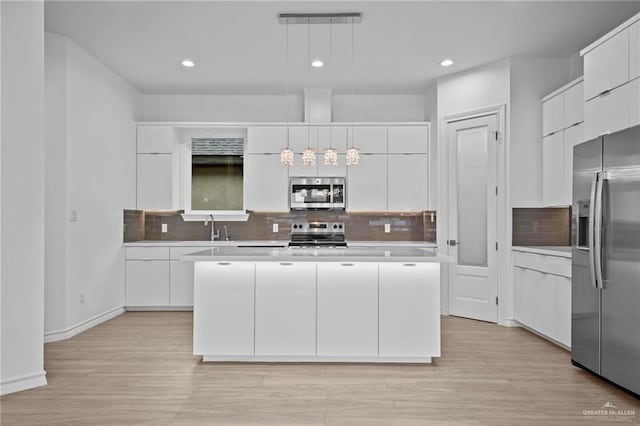 kitchen with white cabinetry, modern cabinets, appliances with stainless steel finishes, and a center island