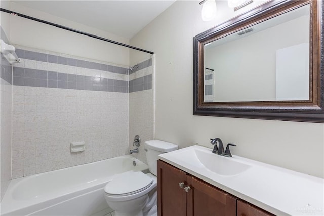 full bathroom with tiled shower / bath, vanity, and toilet