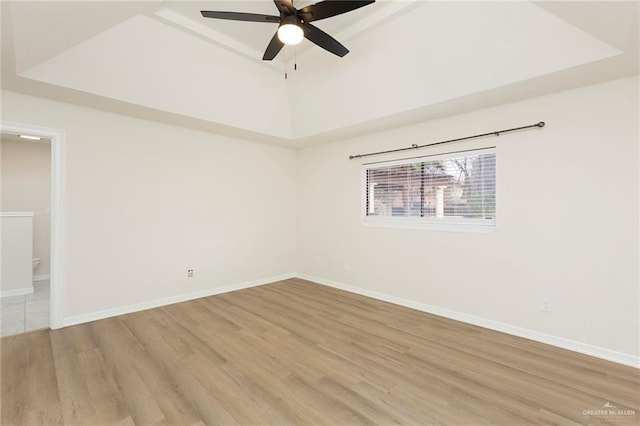 spare room featuring hardwood / wood-style floors, a tray ceiling, and ceiling fan