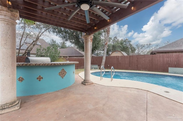 view of pool with a patio area, ceiling fan, and exterior kitchen