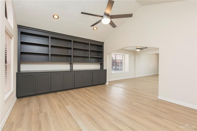 unfurnished living room featuring light hardwood / wood-style flooring, vaulted ceiling, and ceiling fan