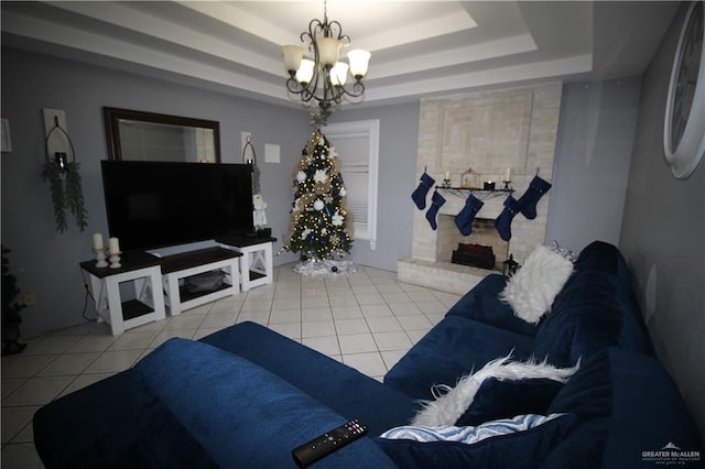 living room with light tile patterned floors, a tray ceiling, and a notable chandelier