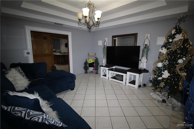 tiled living room with an inviting chandelier and a raised ceiling