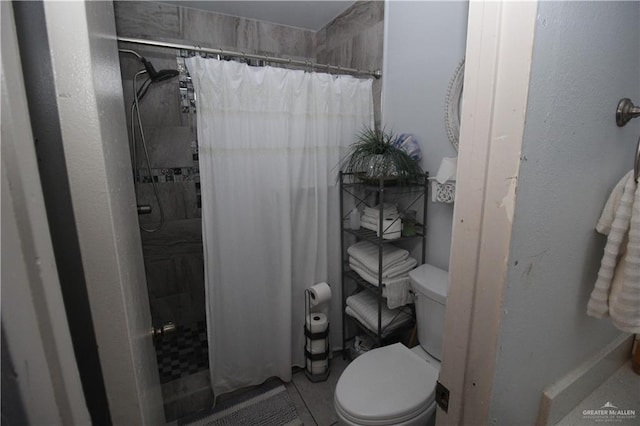 bathroom featuring toilet and curtained shower