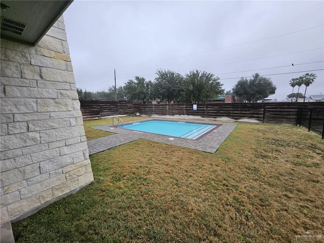 view of swimming pool featuring a lawn, a fenced backyard, and a fenced in pool