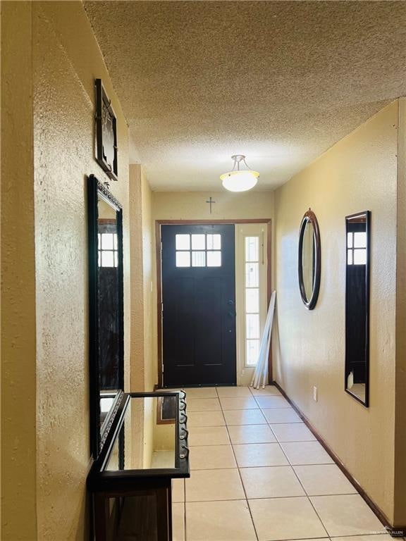 entryway with light tile patterned floors and a textured ceiling