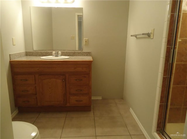 bathroom featuring tile patterned flooring, vanity, toilet, and walk in shower