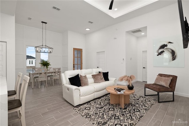 living area featuring a high ceiling, wood finish floors, and visible vents