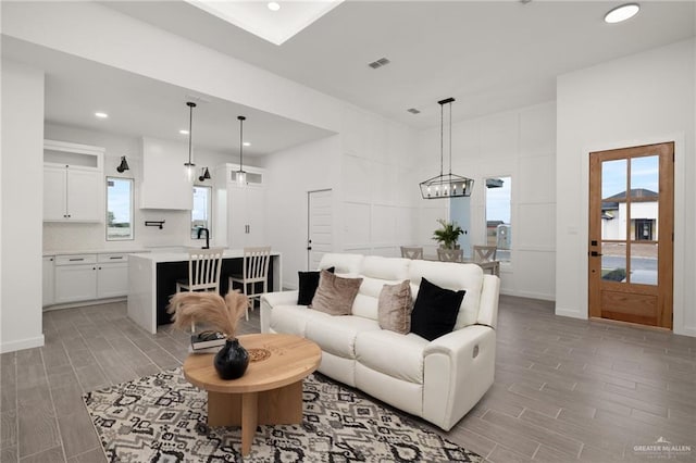 living room featuring wood finish floors, visible vents, baseboards, and recessed lighting