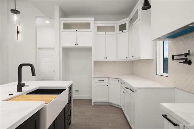 kitchen featuring light stone countertops, tasteful backsplash, and white cabinetry