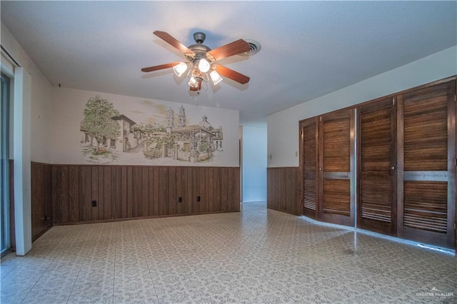 300 W Westway Ave, Mcallen, TX 78501 - unfurnished room featuring wainscoting, a ceiling fan, tile patterned floors, and wood walls