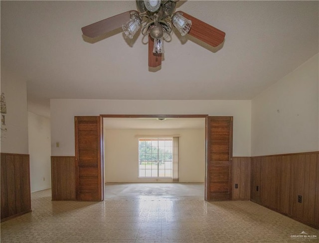 300 W Westway Ave, Mcallen, TX 78501 - unfurnished room with wainscoting, a ceiling fan, wood walls, and tile patterned floors