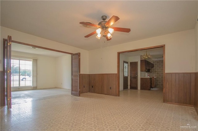 300 W Westway Ave, Mcallen, TX 78501 - unfurnished room with wainscoting, wood walls, a ceiling fan, light flooring, and a chandelier