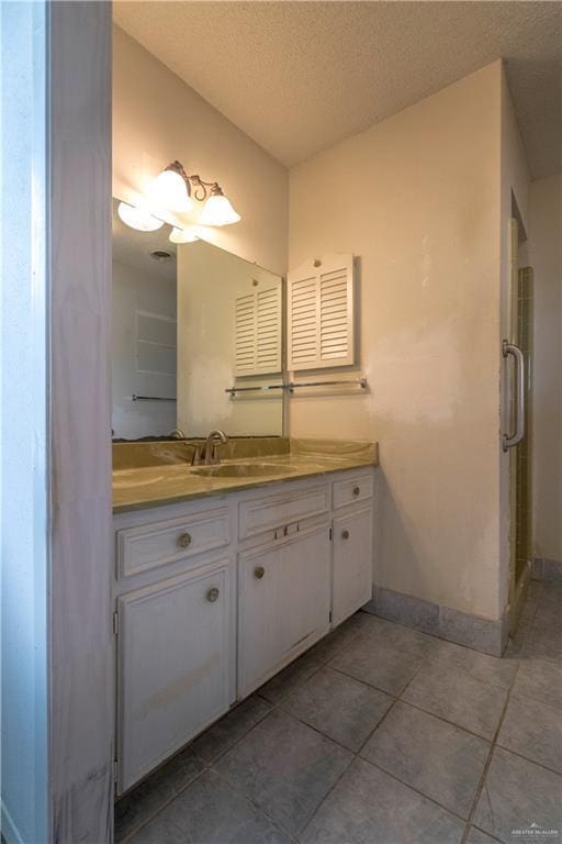 300 W Westway Ave, Mcallen, TX 78501 - bathroom with vanity, tile patterned floors, baseboards, a textured ceiling, and a shower stall