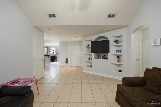 living room featuring built in shelves and light tile patterned flooring