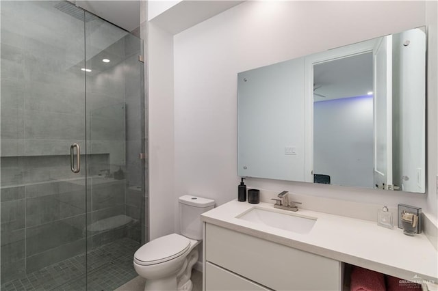 bathroom with vanity, toilet, and a shower with shower door