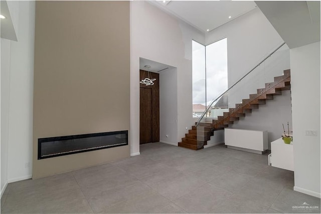 unfurnished living room featuring a high ceiling