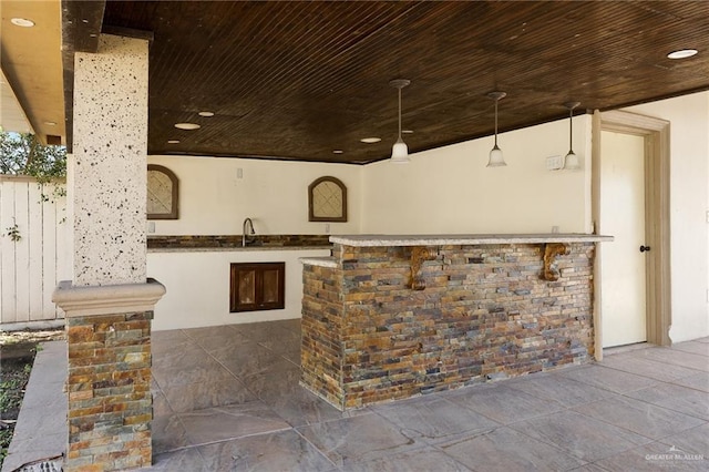 bar featuring wood ceiling, pendant lighting, and sink