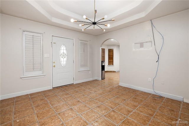 tiled foyer with a chandelier and a tray ceiling