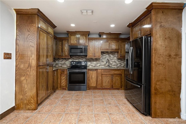 kitchen with light stone countertops, stainless steel appliances, tasteful backsplash, sink, and light tile patterned floors