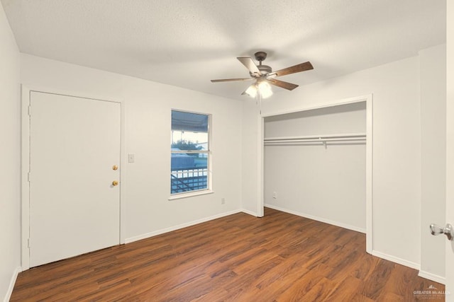 unfurnished bedroom featuring ceiling fan, a textured ceiling, dark hardwood / wood-style flooring, and a closet