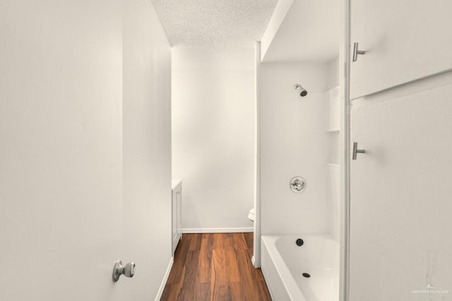 bathroom with wood-type flooring, a textured ceiling, and toilet