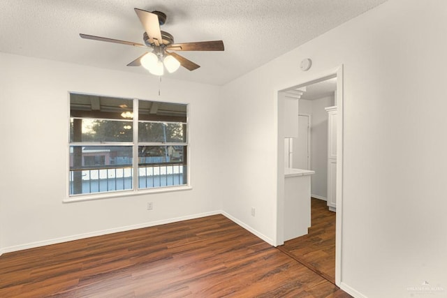 spare room featuring ceiling fan, dark hardwood / wood-style floors, and a textured ceiling