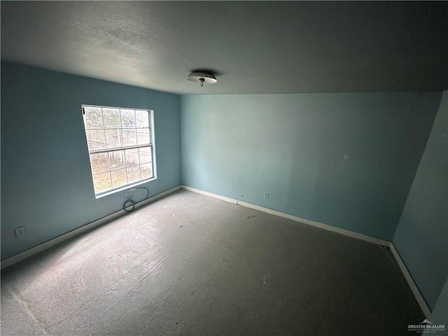 empty room with a textured ceiling and lofted ceiling