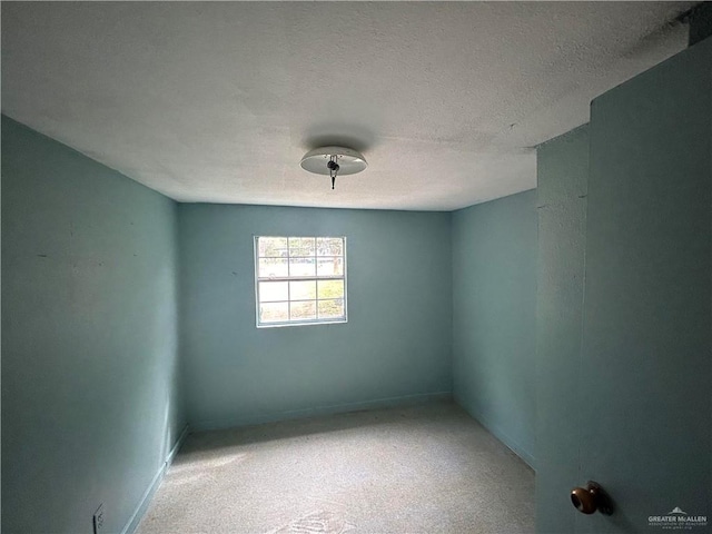 empty room with carpet and a textured ceiling