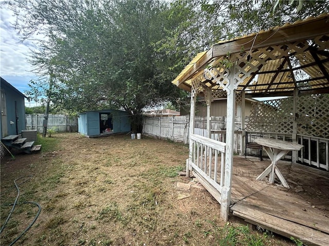 view of yard with a gazebo, a deck, and a storage unit