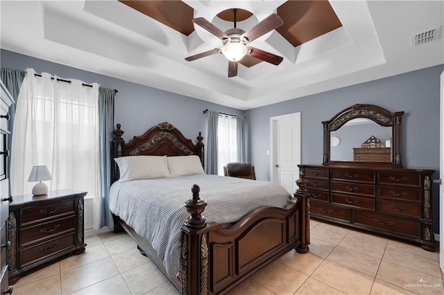 bedroom with ceiling fan, a raised ceiling, and light tile patterned floors