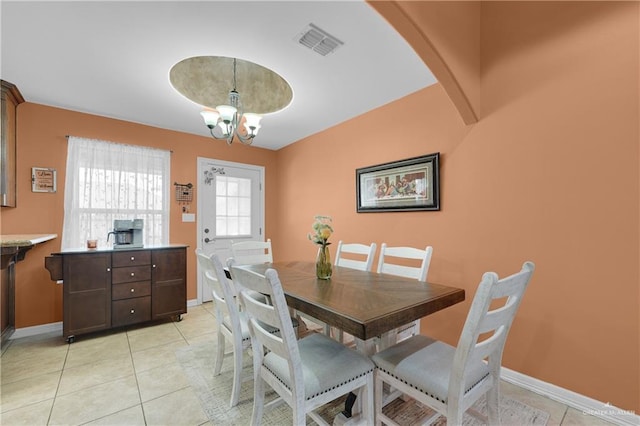 tiled dining space featuring a chandelier