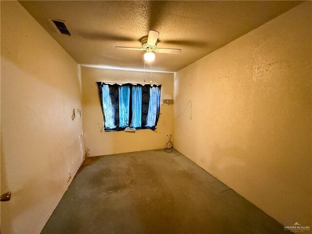 spare room featuring ceiling fan, concrete flooring, and a textured ceiling