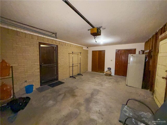 garage featuring a garage door opener and white fridge