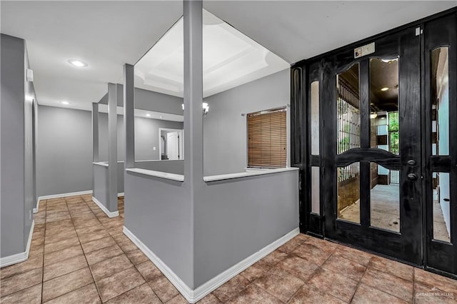 entrance foyer with tile patterned floors and a raised ceiling