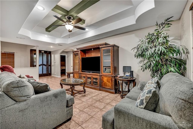 living room featuring ceiling fan, a raised ceiling, and light tile patterned floors