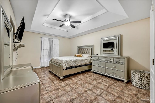 bedroom featuring ceiling fan and a raised ceiling