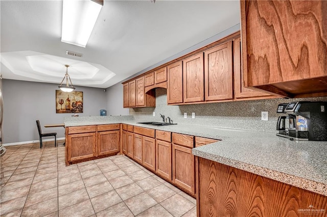 kitchen featuring hanging light fixtures, light tile patterned floors, sink, kitchen peninsula, and backsplash