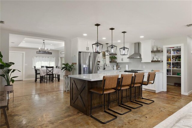 kitchen with open shelves, stainless steel fridge, wall chimney exhaust hood, light countertops, and white cabinetry