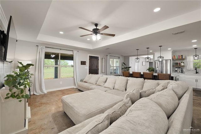 carpeted living area with a wealth of natural light, recessed lighting, visible vents, and ceiling fan