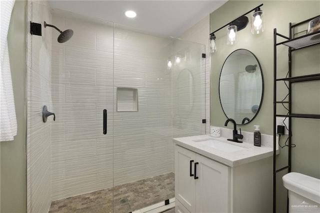 bathroom featuring toilet, recessed lighting, a stall shower, and vanity