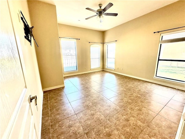 tiled spare room with ceiling fan