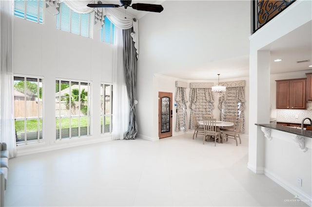 2405 San Alejandro St, Mission, TX 78572 - tiled living room featuring a towering ceiling, a chandelier, healthy amount of natural light, ceiling fan, and baseboards