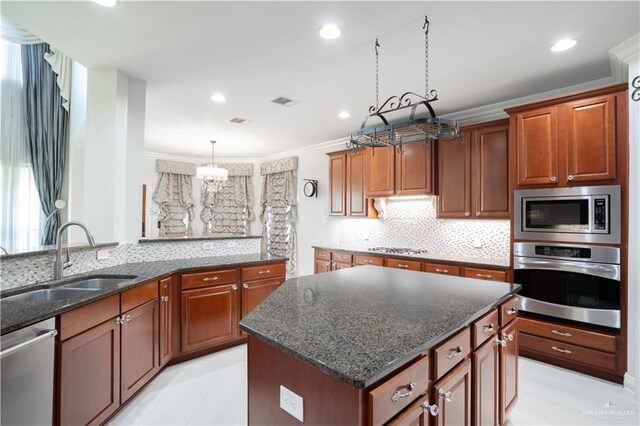 2405 San Alejandro St, Mission, TX 78572 - kitchen with appliances with stainless steel finishes, a sink, decorative backsplash, a center island, and a chandelier
