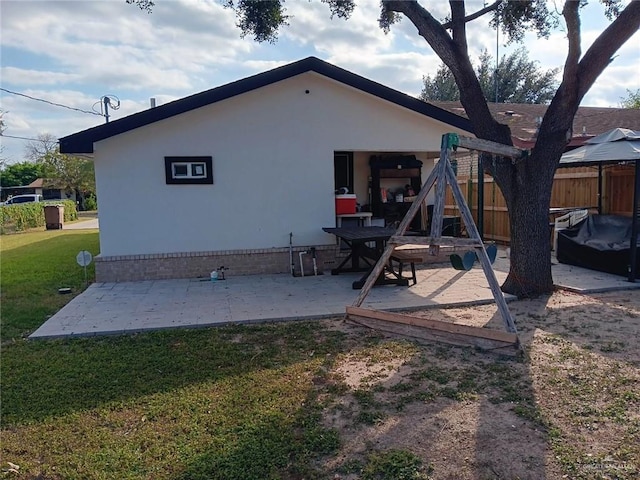 rear view of house featuring a yard, a playground, and a patio area